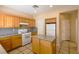 Charming kitchen with an island, wooden cabinets, white appliances, and light countertops at 9849 Ridge Hill Ave, Las Vegas, NV 89147