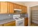 This kitchen has wood cabinets, light countertops, and modern appliances; pantry door is open at 9849 Ridge Hill Ave, Las Vegas, NV 89147