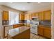 Kitchen area offers a center island, wooden cabinets, granite countertops, and modern appliances at 9849 Ridge Hill Ave, Las Vegas, NV 89147