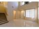 Bright living room featuring high ceilings, staircase, and multiple windows at 9849 Ridge Hill Ave, Las Vegas, NV 89147