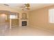 Bright living room with a ceiling fan, fireplace, and tile flooring that connects to other rooms at 9849 Ridge Hill Ave, Las Vegas, NV 89147