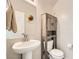 Cozy half-bathroom with a pedestal sink and rustic wood storage cabinet for a charming and practical design at 4454 Lantern Point Ave, North Las Vegas, NV 89084