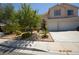 Inviting front yard with mature trees, a well-maintained lawn, and a spacious driveway leading to the garage at 10417 Niagara Falls Ln, Las Vegas, NV 89144