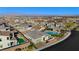An aerial view features a neighborhood with modern homes, a community pool, and well-kept lawns at 11700 Belorado Ave, Las Vegas, NV 89138