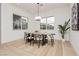 Bright dining room features modern chandelier, large windows, and an elegant wooden table with seating for six at 11700 Belorado Ave, Las Vegas, NV 89138