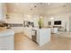 A kitchen featuring white cabinets, a central island, and stainless steel appliances adjacent to a living room space at 11700 Belorado Ave, Las Vegas, NV 89138