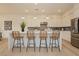 A kitchen island featuring bar stool seating, modern pendant lights, and a view of an adjacent dining room area at 11700 Belorado Ave, Las Vegas, NV 89138