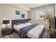 Staged bedroom with a queen sized bed, two end tables with lamps, art on the wall, and large window at 1405 Vegas Valley Dr # 226, Las Vegas, NV 89169