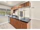 Galley kitchen featuring dark counters, updated cabinets, stainless steel dishwasher and an open view of living area at 1405 Vegas Valley Dr # 226, Las Vegas, NV 89169