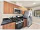 Modern kitchen features dark marble counters, stainless steel appliances, and wood cabinets at 1405 Vegas Valley Dr # 226, Las Vegas, NV 89169