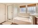 Bright bathroom features a glass-enclosed shower and soaking tub at 1684 Flores Ln, Henderson, NV 89012