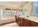 Bright bathroom featuring dual sinks and a large soaking tub with tile surround at 1684 Flores Ln, Henderson, NV 89012