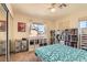 Comfortable bedroom with a ceiling fan, sliding mirror door closet, and bookshelves at 1684 Flores Ln, Henderson, NV 89012