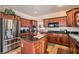 Stylish kitchen featuring stainless steel appliances, wood cabinetry, and dark countertops at 1684 Flores Ln, Henderson, NV 89012