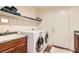 Efficient laundry room with washer, dryer, sink, and upper shelving at 1684 Flores Ln, Henderson, NV 89012