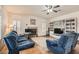 Spacious living room with a ceiling fan, fireplace, and built-in bookshelves at 1684 Flores Ln, Henderson, NV 89012