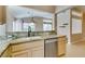 Kitchen sink with granite countertops and stainless steel dishwasher overlooking living room at 2175 Point Mallard Dr, Henderson, NV 89012