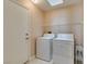 A laundry room with washer, dryer, door, and a storage shelf at 2175 Point Mallard Dr, Henderson, NV 89012