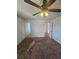 Spacious bedroom with plush carpeting, ceiling fan, and doors to hall and doorway to adjacent bath at 2232 Aspen Mirror Way # 204, Laughlin, NV 89029