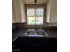 This kitchen features a stainless steel dual sink, granite countertops, and mosaic backsplash at 2232 Aspen Mirror Way # 204, Laughlin, NV 89029