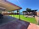 Backyard with artificial grass, covered patio, and pergola with privacy fence at 3105 Palo Verde Dr, Laughlin, NV 89029
