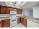 Kitchen featuring wood cabinets, tile countertops, a white dishwasher, oven, and microwave at 3411 Sunfish Dr # B, Henderson, NV 89014