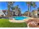 Resort-style pool area surrounded by palm trees, lounge chairs, and well-maintained landscaping at 3411 Sunfish Dr # B, Henderson, NV 89014