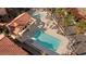 Aerial view of a community pool showcasing the spa, lounge area, cabana, lush landscaping and surrounding tile roofs at 3426 Dry Gulch Dr, Laughlin, NV 89029