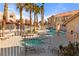 Inviting community pool area with spa, lounge chairs, tables, and lush landscaping, surrounded by a secure fence at 3426 Dry Gulch Dr, Laughlin, NV 89029