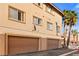 Two-story townhome exterior with beige stucco, tile roof, and two-car garage, accented by palm trees at 3426 Dry Gulch Dr, Laughlin, NV 89029