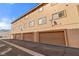 Townhome featuring multiple units with tan stucco, brown garages, and neatly striped parking at 3426 Dry Gulch Dr, Laughlin, NV 89029