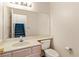 Cozy half bathroom featuring a vanity, toilet, and mirrored wall at 3426 Dry Gulch Dr, Laughlin, NV 89029