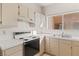 A well lit kitchen with white countertops, stainless steel sink, and tan cabinetry at 3426 Dry Gulch Dr, Laughlin, NV 89029