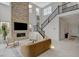 Bright living room with high ceilings, fireplace with stone accent wall and stairs leading up to second level at 350 Gandara St, Las Vegas, NV 89138