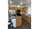 Kitchen with stainless steel refrigerator and black appliances plus dark countertops and oak cabinets at 3637 Pinnate Dr, Las Vegas, NV 89147