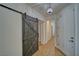Hallway featuring stylish barn door, tile flooring, and contemporary light fixture at 3854 E Chaffe Ave, Pahrump, NV 89061