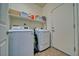Bright laundry room with modern washer, dryer, shelving, and exterior access door at 3854 E Chaffe Ave, Pahrump, NV 89061