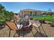 Cozy backyard seating area with a fire pit, chairs, and a manicured lawn at 4680 Suntree Ct, Pahrump, NV 89061