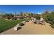 Manicured backyard with lush grass, decorative rocks, and a cozy fire pit seating area at 4680 Suntree Ct, Pahrump, NV 89061