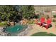 Backyard oasis with pond, rock waterfall feature, Adirondack chairs, and lush landscaping at 4680 Suntree Ct, Pahrump, NV 89061