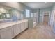 Bathroom with double sinks, tile flooring, large mirror, and walk-in shower at 4680 Suntree Ct, Pahrump, NV 89061