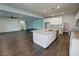 Open-concept kitchen featuring a large granite island, stainless steel appliances, and wood-style flooring at 4680 Suntree Ct, Pahrump, NV 89061