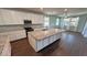 Bright kitchen features white cabinets, granite countertops, and a large island with a sink at 4680 Suntree Ct, Pahrump, NV 89061