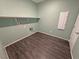 Laundry room with shelf, light-green paint, and dark wood floors at 4680 Suntree Ct, Pahrump, NV 89061
