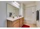 Bathroom with a single sink vanity, a large mirror, and a shower-tub combo at 50 Aura De Blanco St # 19203, Henderson, NV 89074