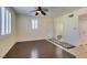 Bright living room with plantation shutters, ceiling fan, and dark hardwood floors at 50 Aura De Blanco St # 19203, Henderson, NV 89074