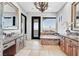 Elegant bathroom featuring dual vanities, a soaking tub, and hillside views at 503 Aaron Way, Boulder City, NV 89005