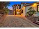 Elegant home featuring stone accents, a brick driveway, and ornate double doors, surrounded by desert vegetation at 503 Aaron Way, Boulder City, NV 89005