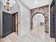 Hallway with stone archway entrance, elevator, and neutral tiling at 503 Aaron Way, Boulder City, NV 89005