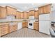 Eat-in kitchen with wood cabinets, granite counters, tile floors, and modern appliances at 503 Aaron Way, Boulder City, NV 89005